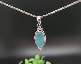 May include: A silver chain necklace with a pendant featuring a light blue oval gemstone set in a silver bezel.