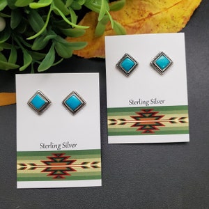 Puede incluir: Un par de pendientes de plata de ley con piedras turquesa engastadas en forma cuadrada. Los pendientes se muestran en una tarjeta blanca con un diseño de estilo suroeste y las palabras "Sterling Silver".