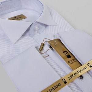 May include: White dress shirt with a pleated front and French cuffs. The shirt has a gold label with the text "ARON IMANI Made in Turkey" and a gold ribbon with the text "ARON IMANI".