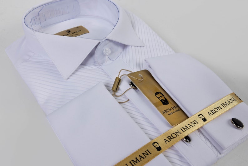 May include: White dress shirt with a pleated front and French cuffs. The shirt has a gold label with the text "ARON IMANI Made in Turkey" and a gold ribbon with the text "ARON IMANI".