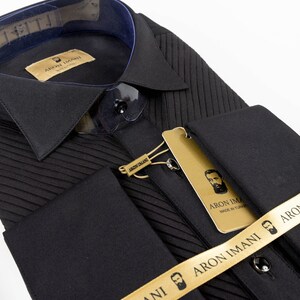 May include: Black dress shirt with a pleated front and French cuffs. The shirt has a gold label with the text "ARON IMANI" and a small image of a man with a beard. The shirt is also adorned with a gold ribbon with the text "ARON IMANI" and a small image of a man with a beard.