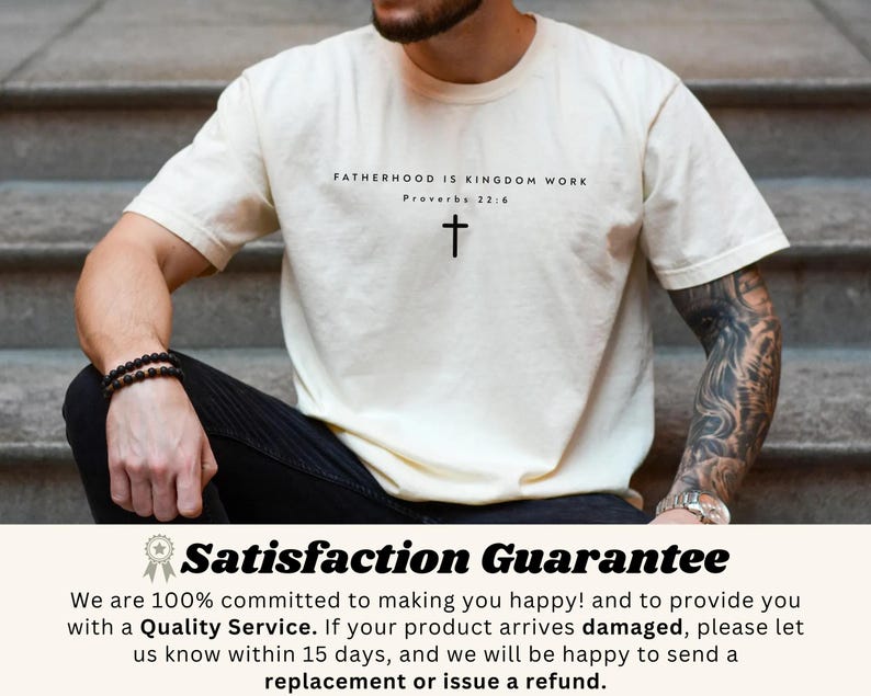 Puede incluir: Camiseta color crema con el texto "FATHERHOOD IS KINGDOM WORK" y una cruz. El texto "Proverbios 22:6" est&aacute; debajo. La camiseta la lleva una persona sentada en unos escalones.