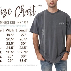 May include: A dark gray Comfort Colors 1717 garment-dyed heavyweight t-shirt. The image includes a size chart with measurements in inches for sizes S to 4XL. The model is wearing an XL. The shirt's width ranges from 18.5" to 29", and the length from 27" to 33.5".