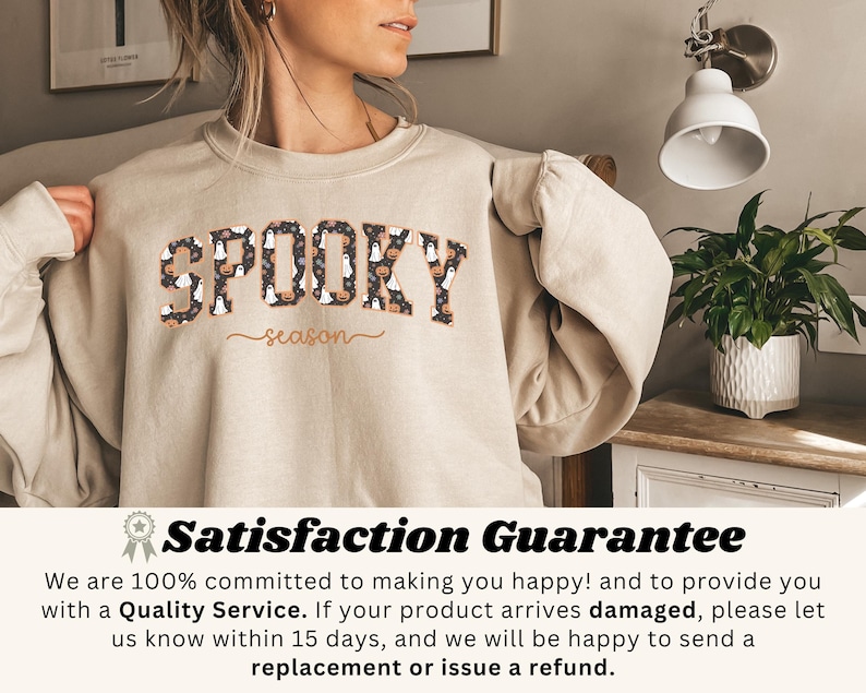May include: Beige sweatshirt with the text "SPOOKY season" in a black and orange font. The word "SPOOKY" is filled with Halloween-themed patterns. The sweatshirt is made of a soft material.