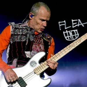 Pode incluir: Um músico veste uma camisa laranja de manga comprida sob um colete de patchwork texturizado com vários padrões, tocando um baixo elétrico prateado. A guitarra tem um autocolante circular com um crânio e o texto FLEA escrito.