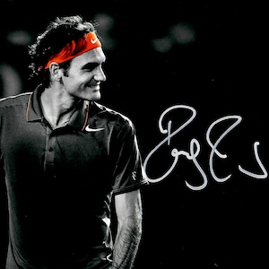 May include: Black and white image of a man wearing a red headband and wristband, with a Nike logo. He is wearing a dark polo shirt with the Nike swoosh. The image includes a signature in white on a black background.