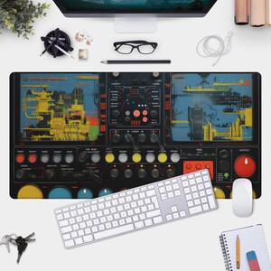 以下が含まれることがあります： ボタン、ノブ、デジタルディスプレイを備えたコントロールパネルを特徴とする、未来的なデザインの黒と青のデスクマット。マットには「SYNCED」というテキストが表示されています。