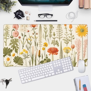 Puede incluir: Un tapete de escritorio con temática floral con fondo blanco y una variedad de flores y plantas coloridas. El tapete es perfecto para agregar un toque de naturaleza a tu espacio de trabajo.