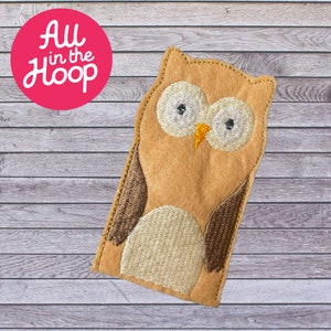 May include: A brown felt finger puppet shaped like an owl with large white eyes and a yellow beak. The owl has brown wings and a beige belly.