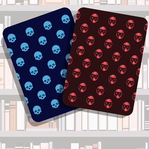 May include: Two rectangular coasters with rounded corners. One is navy blue with light blue skulls, the other is maroon with red helmet designs. The background shows a bookshelf with white books.