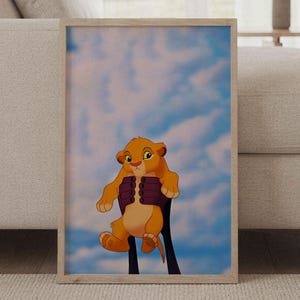 Può includere: Una stampa artistica da parete incorniciata raffigurante un cucciolo di leone dei cartoni animati con pelo dorato e grandi occhi tenuto in alto contro un cielo blu con nuvole bianche. Il cucciolo ha pancia e zampe beige chiaro.