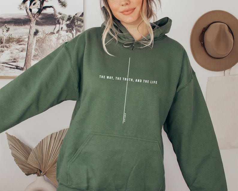 May include: A dark green hooded sweatshirt with the text "The way, the truth, and the life" printed on the front. The text is in white and is centered on the sweatshirt.