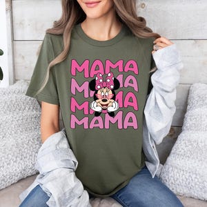 May include: A green t-shirt with a pink graphic of Mickey Mouse's girlfriend Minnie Mouse with the word "MAMA" repeated four times.