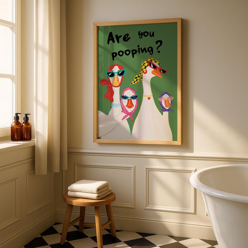 May include: A framed art print featuring a whimsical illustration of three geese wearing sunglasses and scarves. The text "Are you pooping?" is written in black. The artwork is displayed in a bathroom setting.