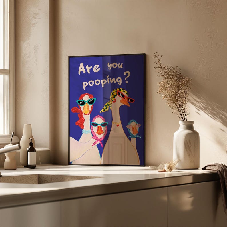 May include: Framed art print featuring three geese wearing sunglasses and scarves against a blue background. The text "Are you pooping?" is displayed at the top. The artwork is displayed in a modern kitchen setting.