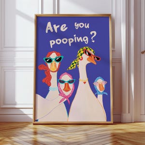 May include: Framed art print featuring a whimsical illustration of three geese wearing sunglasses and scarves against a deep blue background. The text "Are you pooping?" is displayed in white. The artwork is framed in a gold-colored frame.