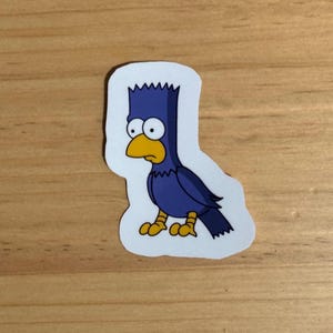 May include: A blue bird sticker with a yellow beak and eyes. The bird has a spiky blue hairdo.