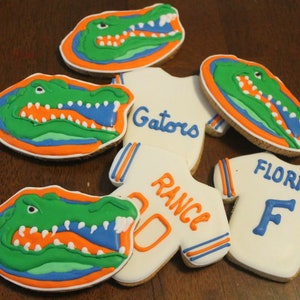 May include: A set of six decorated sugar cookies featuring the University of Florida Gators mascot, an alligator, and the words "Gators", "Florida", and "Rance".