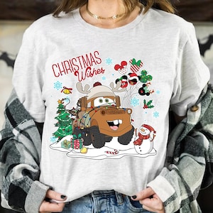 May include: A white t-shirt with a Christmas themed design featuring a cartoon tow truck with a snowman and the text "Christmas Wishes".