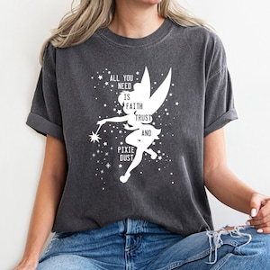 May include: A dark gray t-shirt with a white silhouette of Tinkerbell and the text "All you need is faith, trust and pixie dust".