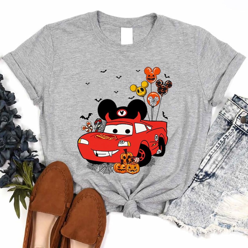 a gray shirt with mickey mouse driving a red car