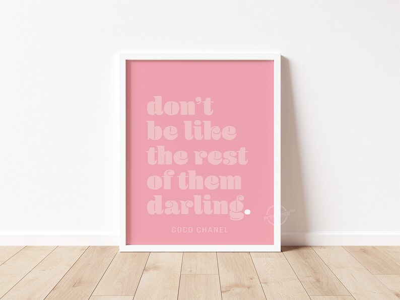 Puede incluir: Impresi&oacute;n enmarcada rosa con fondo blanco y el texto "don't be like the rest of them darling." El texto est&aacute; en negrita, en blanco. La parte inferior de la impresi&oacute;n tiene el texto "COCO CHANEL" en blanco, en una fuente m&aacute;s peque&ntilde;a.