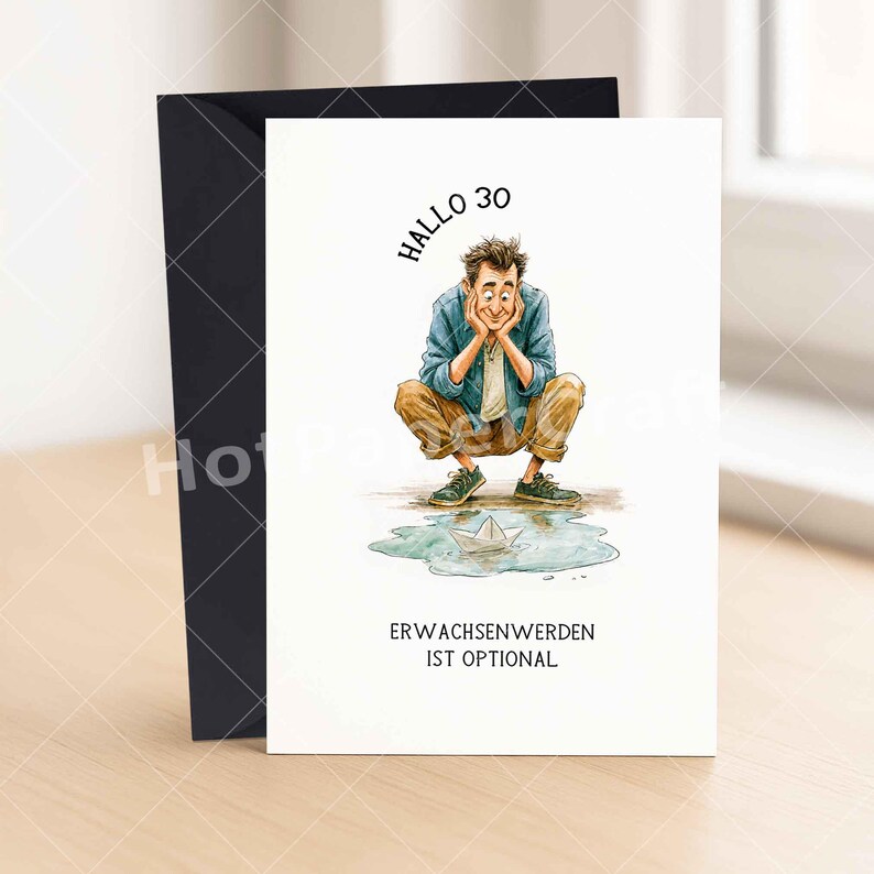 May include: A white greeting card featuring a watercolor illustration of a person crouching and looking at a paper boat in a puddle. The text reads "HALLO 30" at the top and "ERWACHSENWERDEN IST OPTIONAL" at the bottom. A black envelope is behind the card.