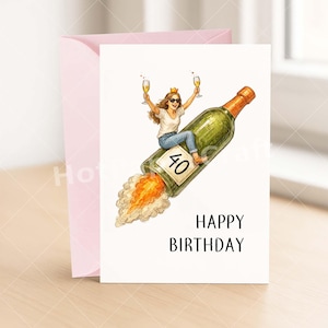 May include: A birthday card with a woman riding a champagne bottle rocket, holding two glasses of champagne. The bottle has a "40" label. The words "HAPPY BIRTHDAY" are printed below the image. A pink envelope is behind the card.