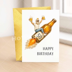 May include: A birthday card with a cartoon illustration of a man riding a beer bottle rocket, holding two mugs of beer. The card reads "Happy Birthday" and features the number "50". A gold envelope is behind the card.