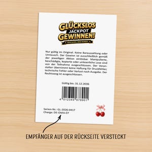 May include: A white card with the text "GL&Uuml;CKSLOS JACKPOT GEWINNEN!" in gold and yellow. The card includes a barcode, cherry graphic, and German text. The bottom of the card reads "EMPF&Auml;NGER AUF DER R&Uuml;CKSEITE VERSTECKT".