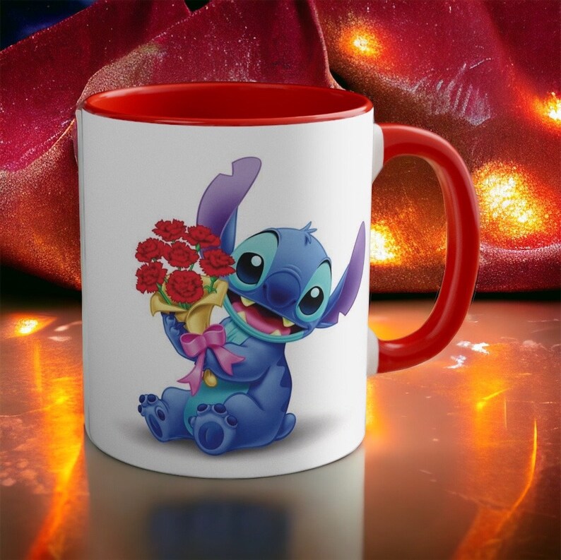 May include: A white ceramic mug with a red rim and handle. The mug features a cartoon image of Stitch from Lilo & Stitch holding a bouquet of red carnations.