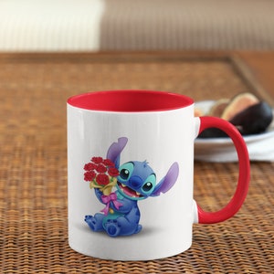 May include: White ceramic mug with a red rim and handle. The mug features a cartoon image of Stitch from Lilo & Stitch holding a bouquet of red flowers.