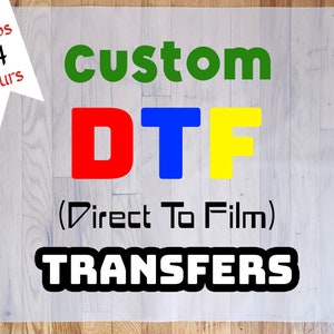 May include: Custom DTF Transfers, a clear sheet with the text "custom DTF (Direct To Film) TRANSFERS" in black, with the letters "DTF" in red, blue, and yellow.