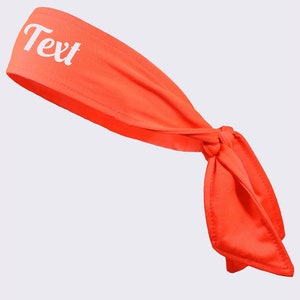 May include: A bright orange headband with a white "Text" inscription. The headband is tied in a knot at the back.