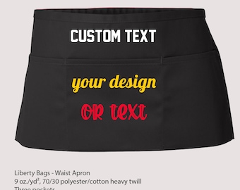 May include: Black waist apron with three pockets. The apron is made of a 70/30 polyester/cotton blend and has a custom text area that says "CUSTOM TEXT your design or text".