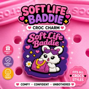 May include: A pink Croc charm with the text "SOFT LIFE BADDIE" in pink and purple. The charm features a white bunny with a purple bow and purse. Additional text includes "Croc Charm", "Perfect Gift", "Durable PVC", "Cute & Trendy", and "Fits All Crocs Styles".