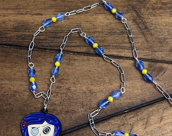 Collier classique en corail avec pendentif yeux en bouton