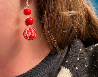 Boucles d'oreilles de Noël enveloppées dans du fil d'argent. Perles d'hiver rouges. Boucles d'oreilles festives