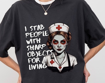 May include: Black t-shirt with a graphic of a zombie nurse with a red cross and the text "I stab people with sharp objects for a living".