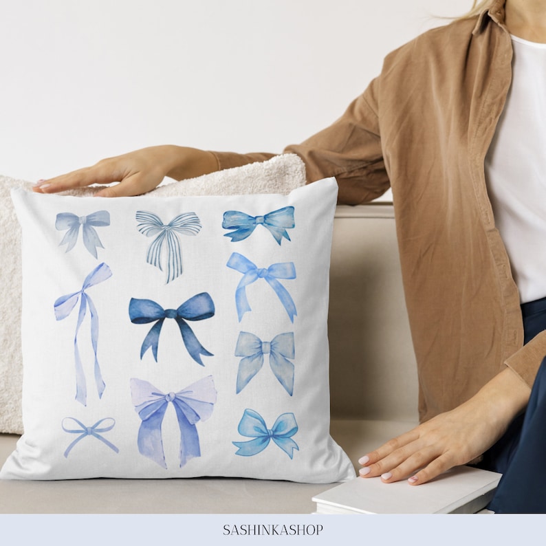 Pode incluir: Uma almofada branca com um design de la&ccedil;o de aquarela azul. A almofada apresenta 10 designs de la&ccedil;o diferentes em v&aacute;rios tons de azul. A almofada est&aacute; sentada em um sof&aacute; branco.