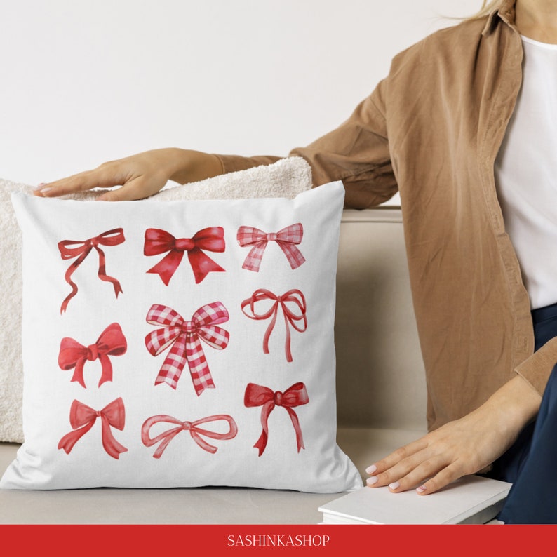 May include: A white pillow with red and white watercolor bows printed on it. The pillow is sitting on a white couch. The text "SASHINKASHOP" is printed on the bottom of the image.