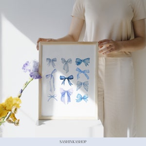 Pode incluir: Uma impress&atilde;o emoldurada com uma ilustra&ccedil;&atilde;o em aquarela de la&ccedil;os azuis em v&aacute;rios estilos e tamanhos. A impress&atilde;o &eacute; em um fundo branco e tem uma moldura de madeira.