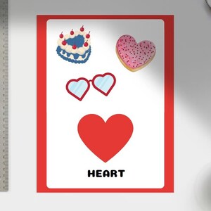 May include: A red heart shape with the word "HEART" printed below it. There are three other heart-shaped objects above it: a blue and white cake with cherries, a pink heart-shaped cookie with sprinkles, and a pair of blue sunglasses.