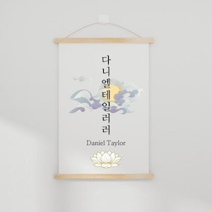 Könnte beinhalten: Ein weißer Leinwanddruck mit einem vertikalen Design aus koreanischer Kalligraphie, einer stilisierten Sonne und Wolken sowie einer Lotusblume. Der Text lautet "다니엘 테일러" und "Daniel Taylor".