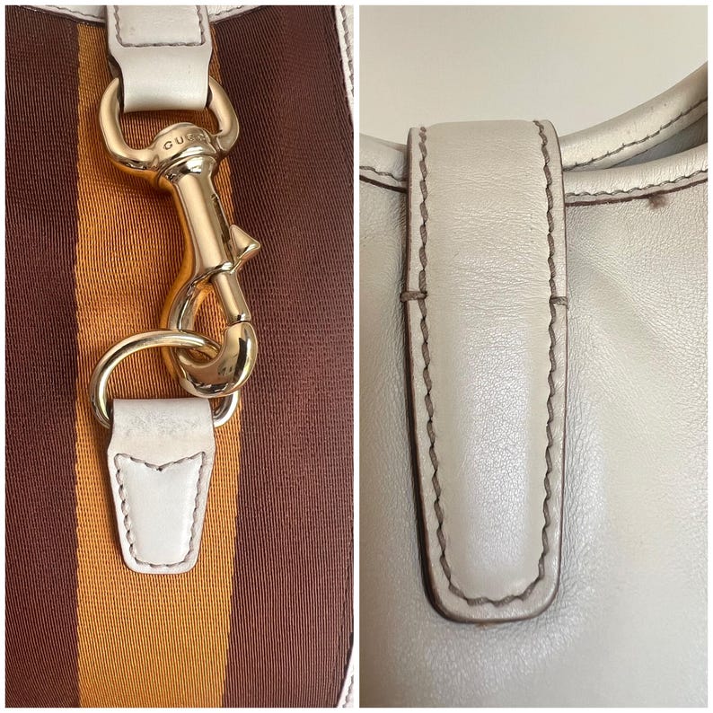 May include: Close-up of a white leather handbag with a gold-toned clasp and brown and orange striped fabric. The bag has a white leather strap with stitching.