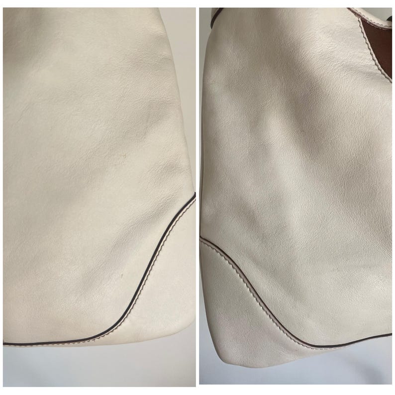 May include: Close-up of the off-white leather of a handbag. The leather has a subtle texture and is stitched with a brown thread.