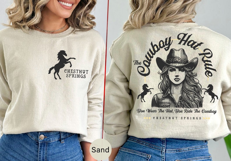 May include: A beige sweatshirt with a black silhouette of a horse and the text "CHESTNUT SPRINGS". The back of the sweatshirt has a black and white illustration of a woman wearing a cowboy hat with the text "The Cowboy Hat Rule" and "You Wear The Hat, You Ride The Cowboy" and "CHESTNUT SPRINGS".