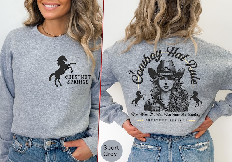 May include: A gray long-sleeve sweatshirt with a black silhouette of a horse and the text "Chestnut Springs" on the front. The back of the sweatshirt features a graphic of a woman wearing a cowboy hat with the text "The Cowboy Hat Rule" and "You Wear The Hat, You Ride The Cowboy" with the text "Chestnut Springs" underneath.