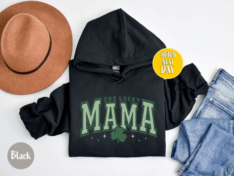 May include: Black hooded sweatshirt with the text "One Lucky Mama" in green with a shamrock graphic.