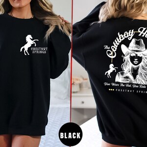 May include: Black sweatshirt with a white horse and the text "Chestnut Springs" on the front and a white graphic of a woman wearing a cowboy hat with the text "The Cowboy Hat Rule" and "You Wear The Hat, You Ride The Cowboy" and "Chestnut Springs" on the back.